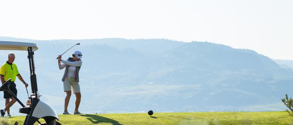 Golfer swinging on course